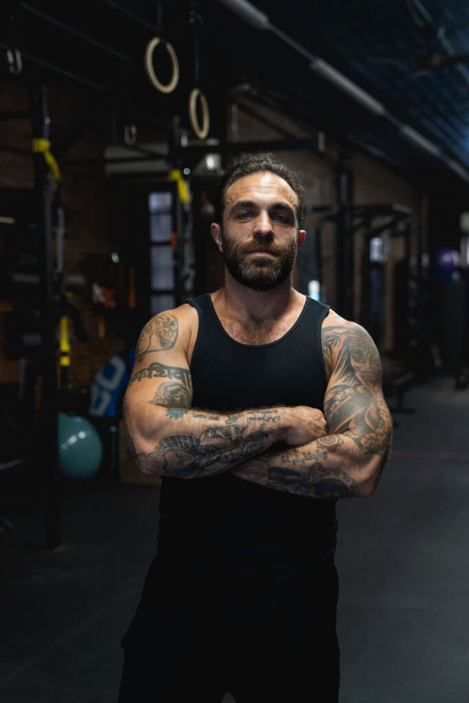 Dave Cash standing with his arms crossed in the gym, calm and direct
