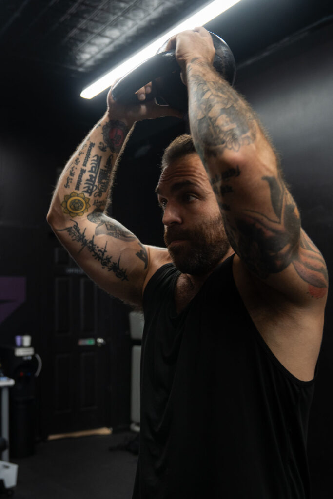 Close view of Dave Cash holding a kettlebell overhead