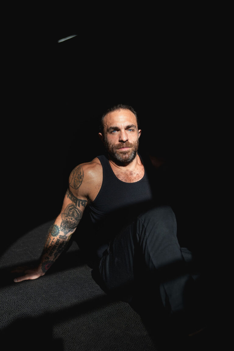 Dave Cash seated in dramatic low light on the gym floor