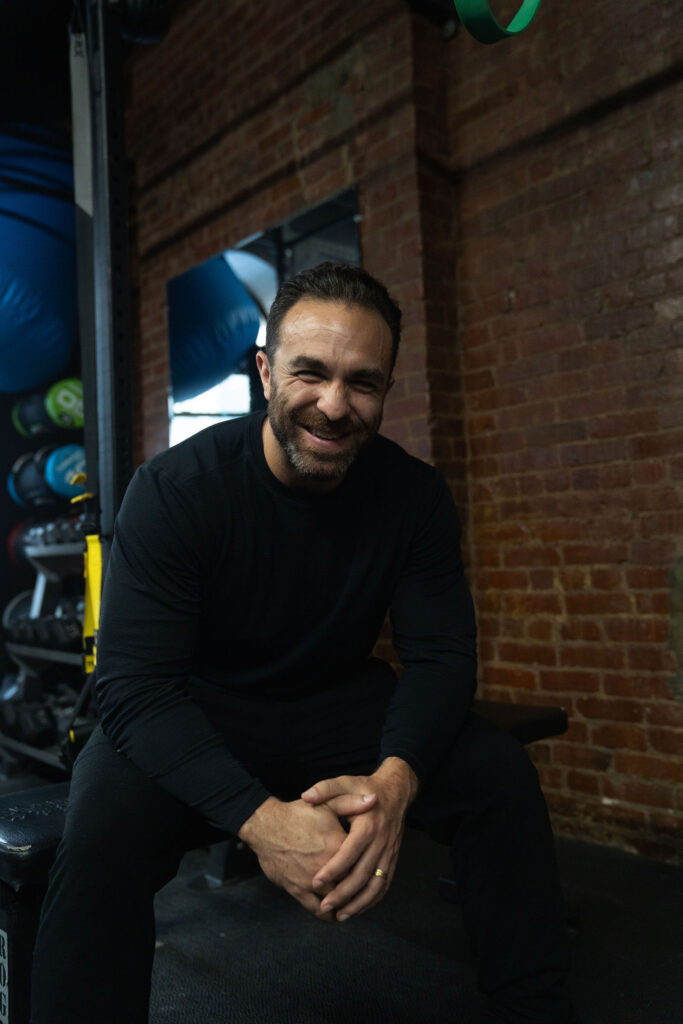 Dave Cash smiling, seated on a bench in the gym