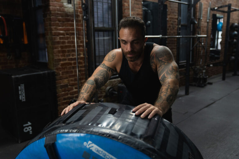 Dave Cash driving into a heavy training tire in the gym